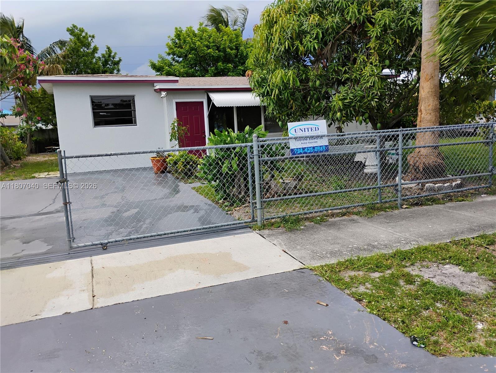 A single-story house with a gray exterior, a paved driveway, and a chain-link fence — 3161 NW 5th St, Lauderhill FL 33311, LAUDERHILL, FL