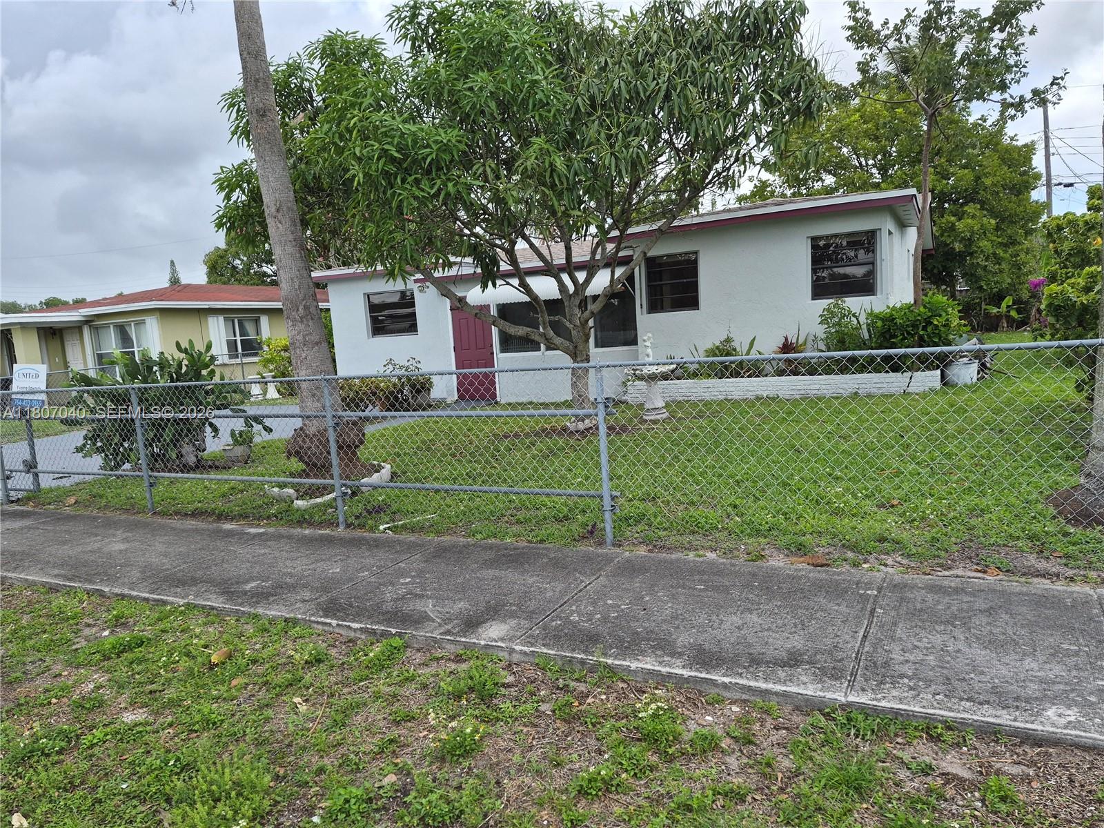 A tiled patio features a white front door and a large window on a brick wall — 3161 NW 5th St, Lauderhill FL 33311, LAUDERHILL, FL