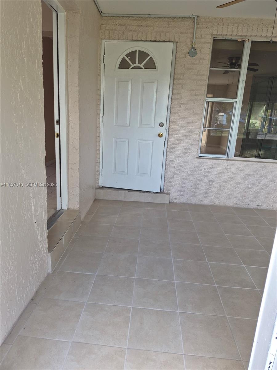 A tiled patio features a white brick wall, a ceiling fan, and open doorways — 3161 NW 5th St, Lauderhill FL 33311, LAUDERHILL, FL