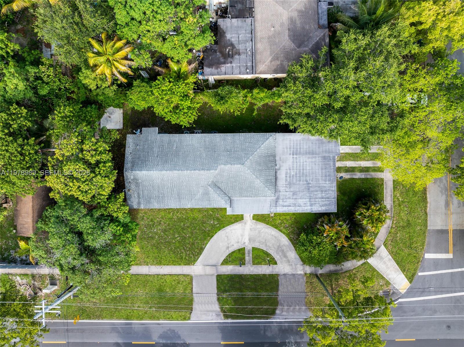 An aerial view shows a house with a gray roof, a circular driveway, and surrounding trees — 12090 NW 12th Ave, North Miami FL 33168, NORTH MIAMI, FL