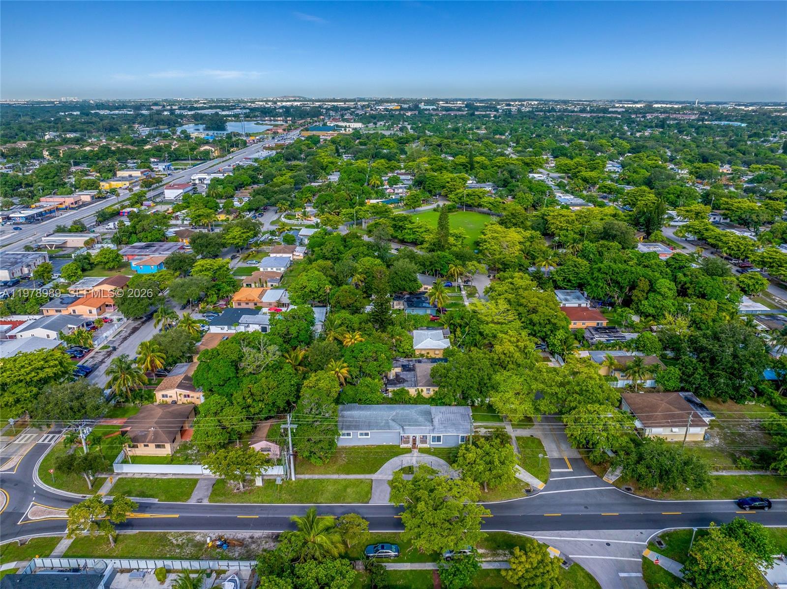 An aerial view shows a single-story house surrounded by trees in a suburban neighborhood — 12090 NW 12th Ave, North Miami FL 33168, NORTH MIAMI, FL