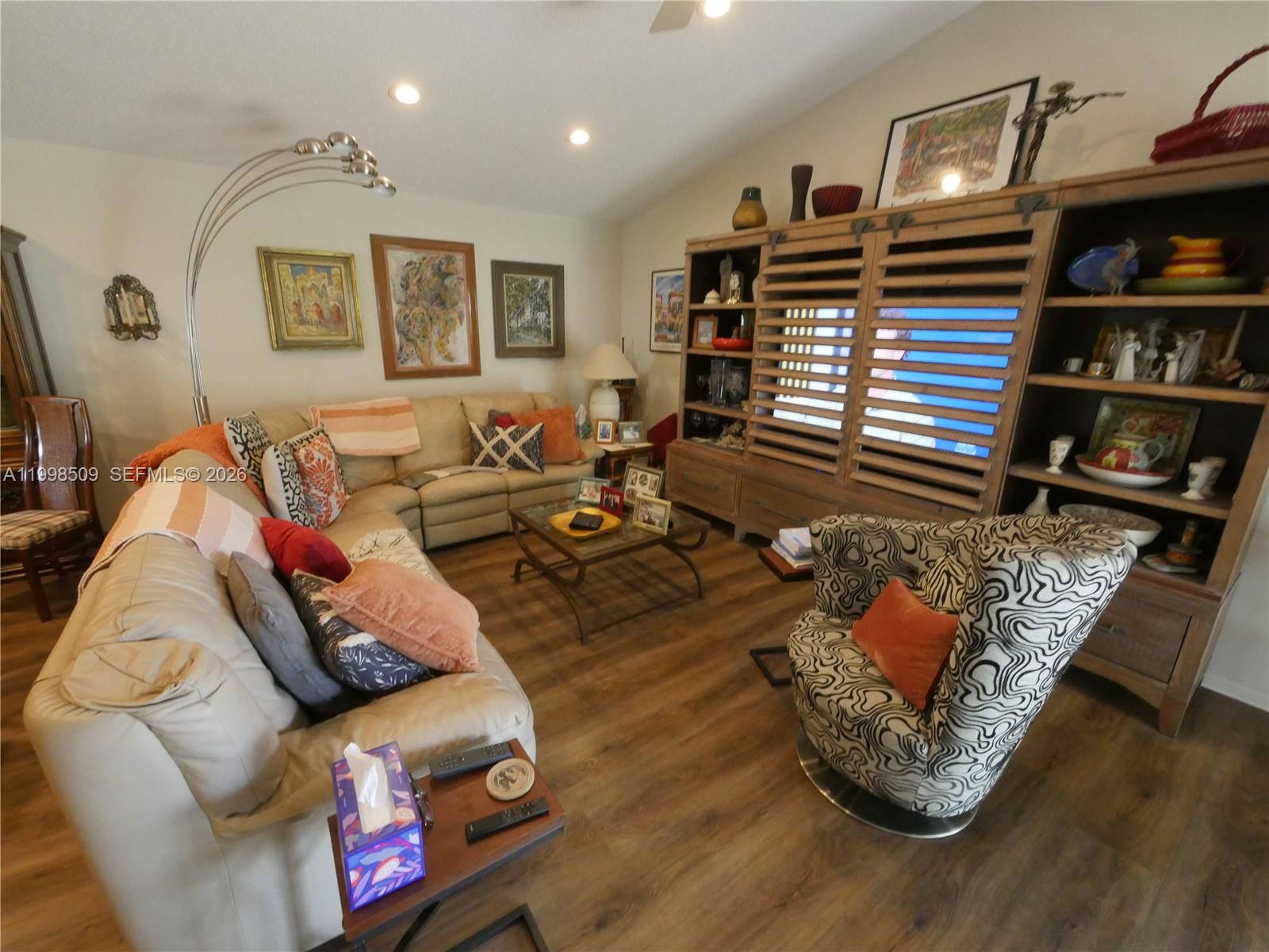 A living room features a sectional sofa, a patterned armchair, and a large wooden entertainment center — 23359 Barlake Dr, Boca Raton FL 33433, BOCA RATON, FL