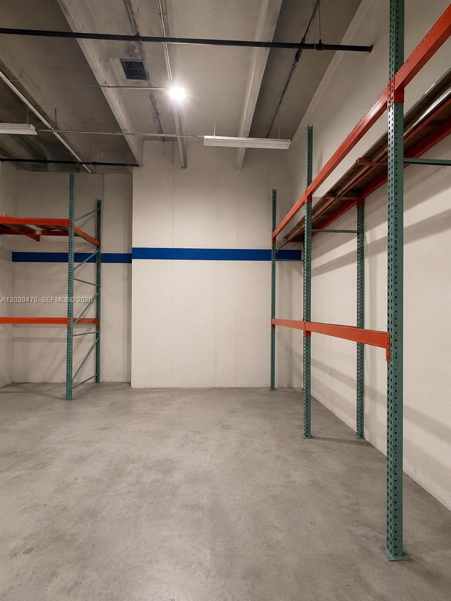 An empty warehouse space features concrete floors, white walls, and industrial metal storage shelving — 8554 NW 61st St, Miami FL 33166, MIAMI, FL