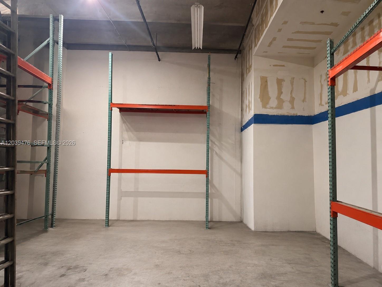 An industrial storage room features concrete floors, white walls, and metal pallet racking units — 8554 NW 61st St, Miami FL 33166, MIAMI, FL