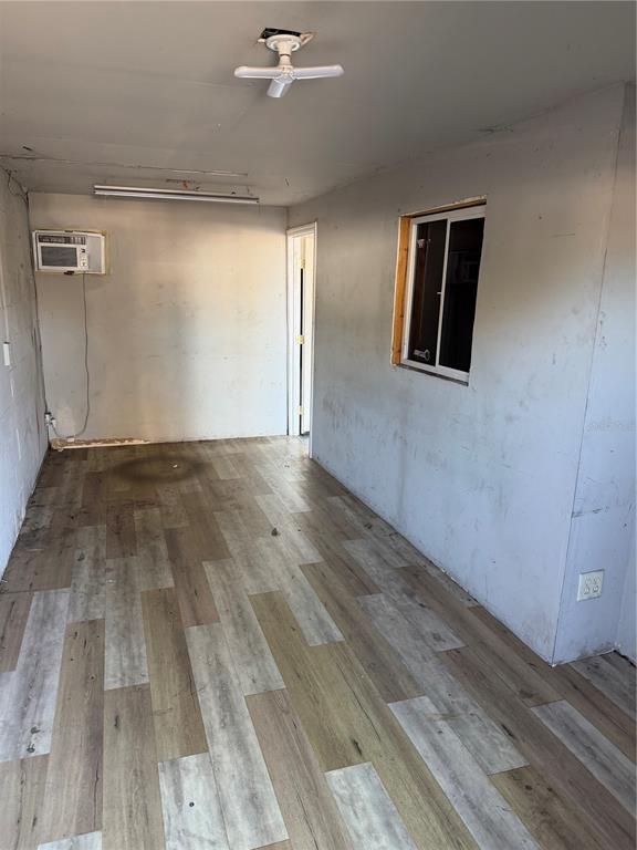 An interior room features light wood-look flooring, gray walls, a window, and a ceiling light — 1302 NW 10TH STREET, OCALA, FL