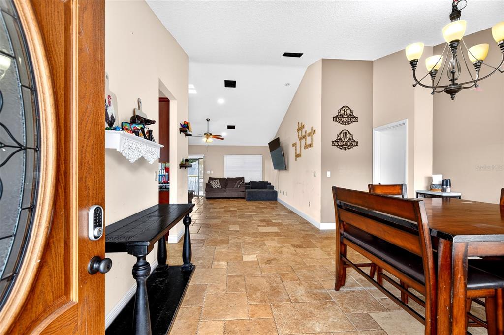 An entryway leads into an open-concept living and dining area with tiled floors and vaulted ceilings — 16362 SE 81ST TERRACE, SUMMERFIELD, FL
