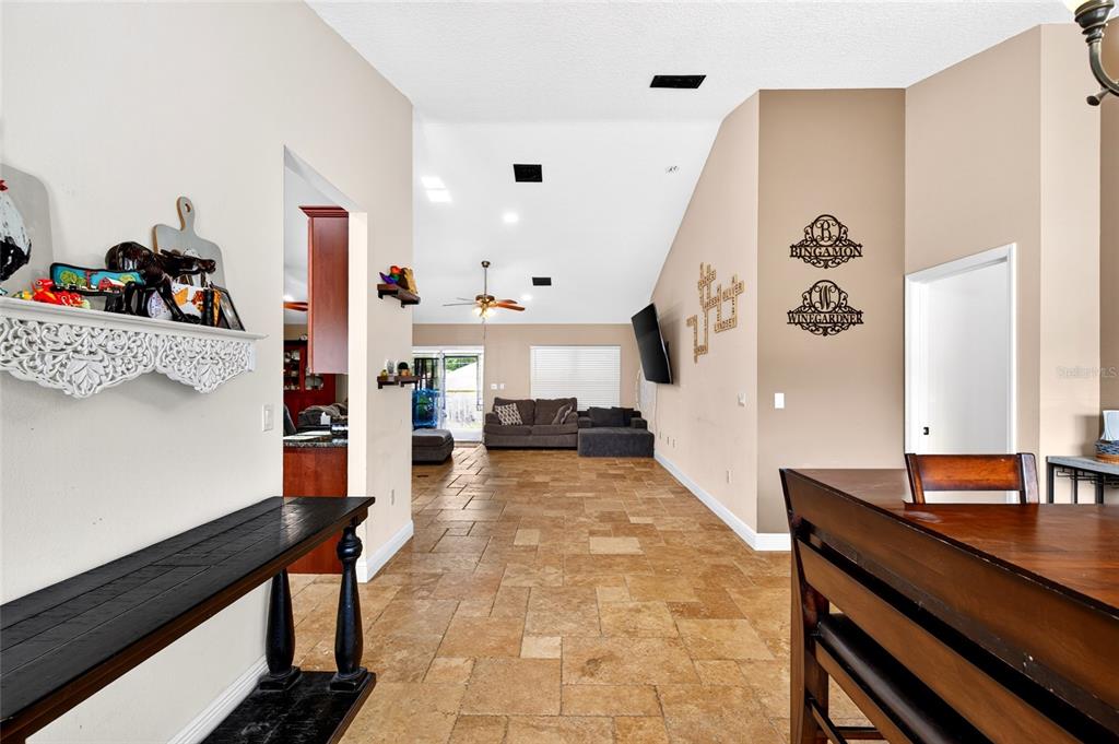 A view from a dining area looking into a living room with tile flooring — 16362 SE 81ST TERRACE, SUMMERFIELD, FL