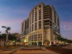 A low-angle exterior view of a multi-story residential building at dusk — 50 CENTRAL AVENUE UNIT 11A, SARASOTA, FL