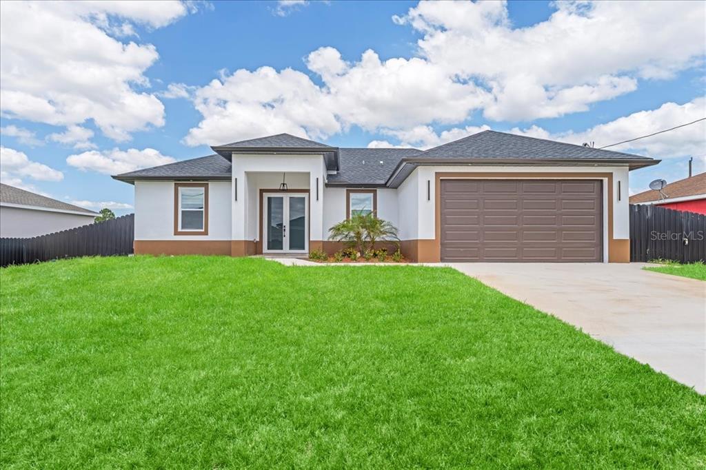 A single-story house with a white facade, brown trim, and a two-car garage — 2914 23RD STREET SW, LEHIGH ACRES, FL