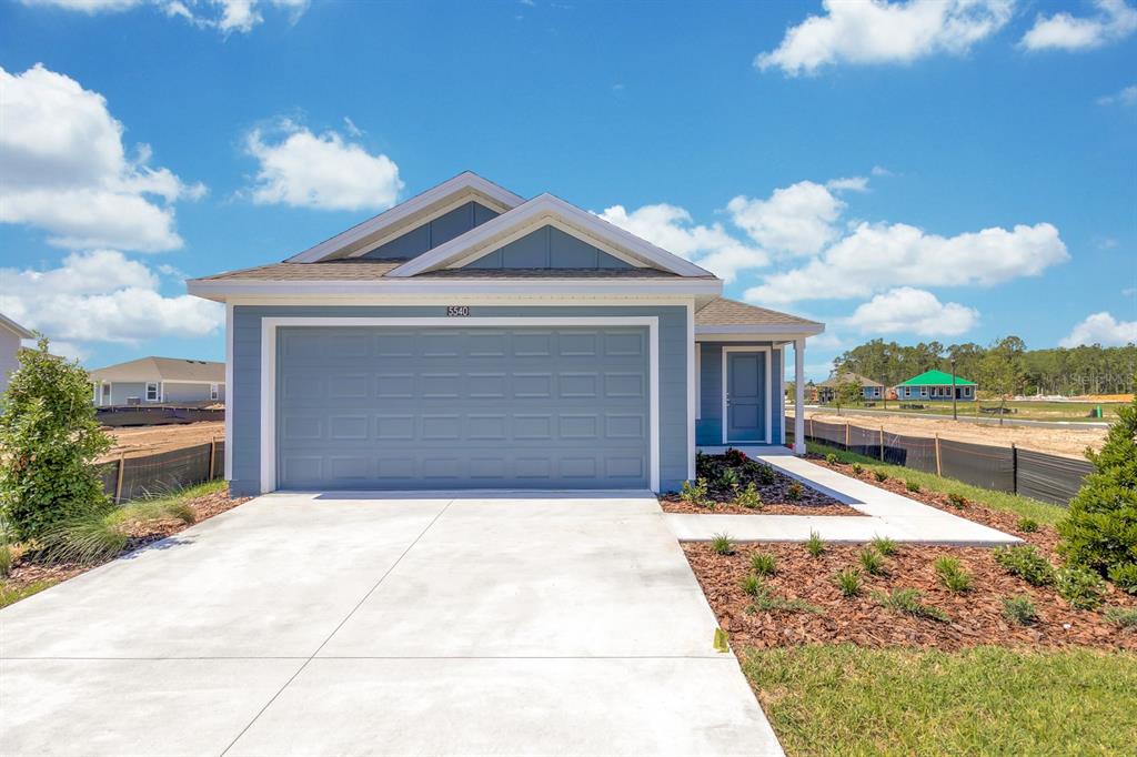 A blue single-story house with a two-car garage and a concrete driveway — 5540 SAPOTE COURT, KISSIMMEE, FL