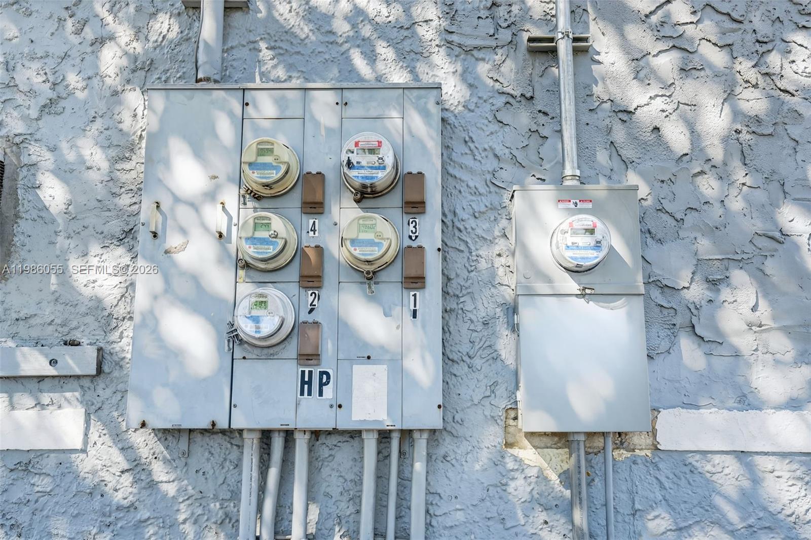 An exterior wall features a large multi-meter electrical panel and a separate single-meter panel — 767 NW 35th St, Miami FL 33127, MIAMI, FL
