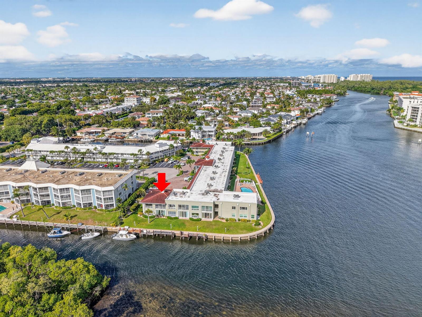 An aerial view shows a waterfront apartment building with a red arrow pointing toward a unit — 711 NE Harbour Terrace # 3120, Boca Raton FL 33431, BOCA RATON, FL