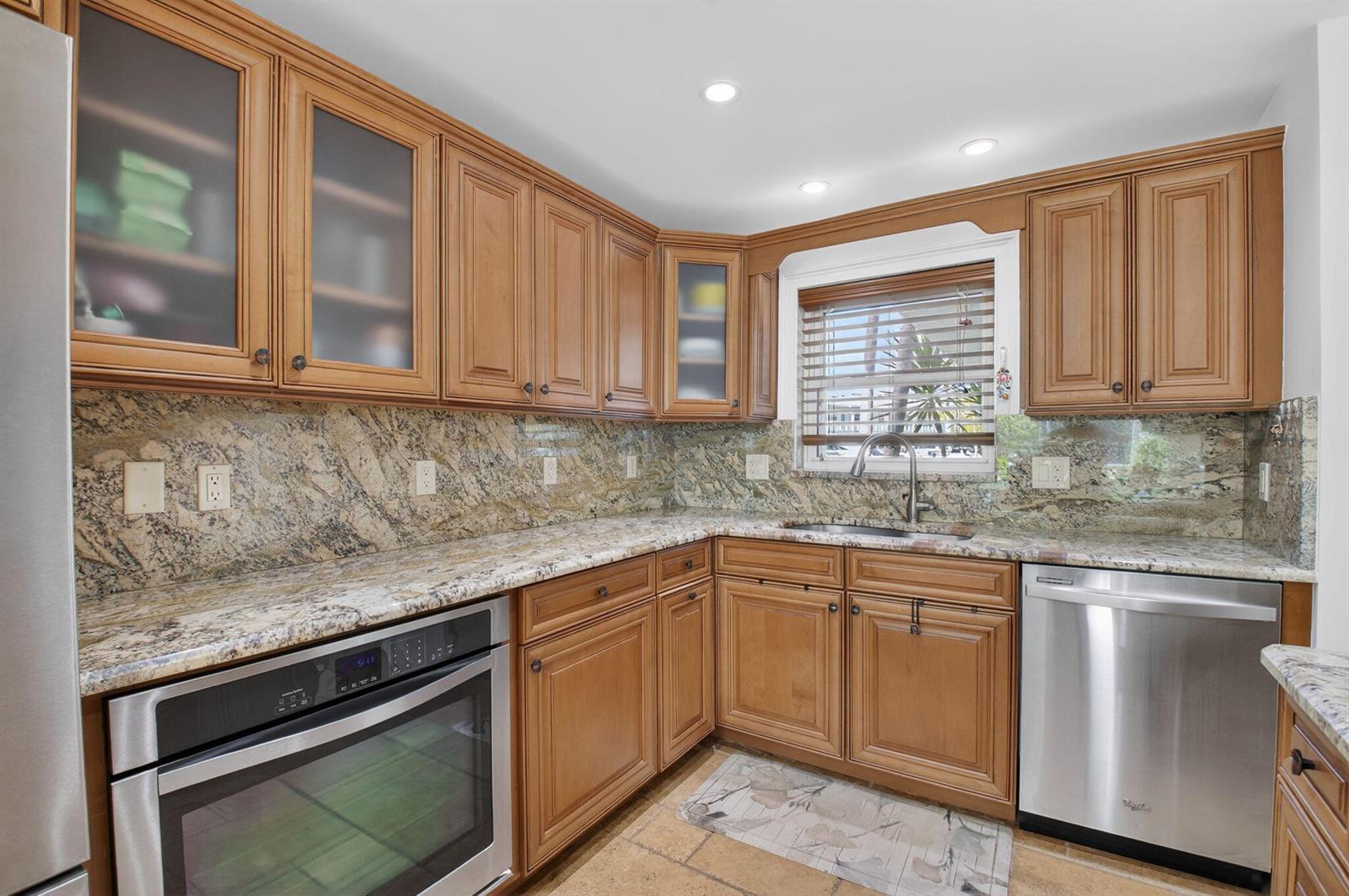 A kitchen features wood cabinets, granite countertops, stainless steel appliances, and a window above the sink — 711 NE Harbour Terrace # 3120, Boca Raton FL 33431, BOCA RATON, FL
