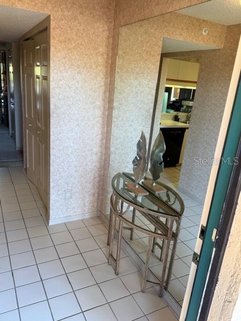 A tiled entryway features a glass-topped console table placed against a large wall mirror — 5525 ASHTON LAKE DRIVE UNIT 5525, SARASOTA, FL