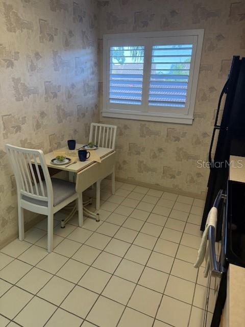 A small dining area features a white table, two chairs, and patterned wallpaper — 5525 ASHTON LAKE DRIVE UNIT 5525, SARASOTA, FL