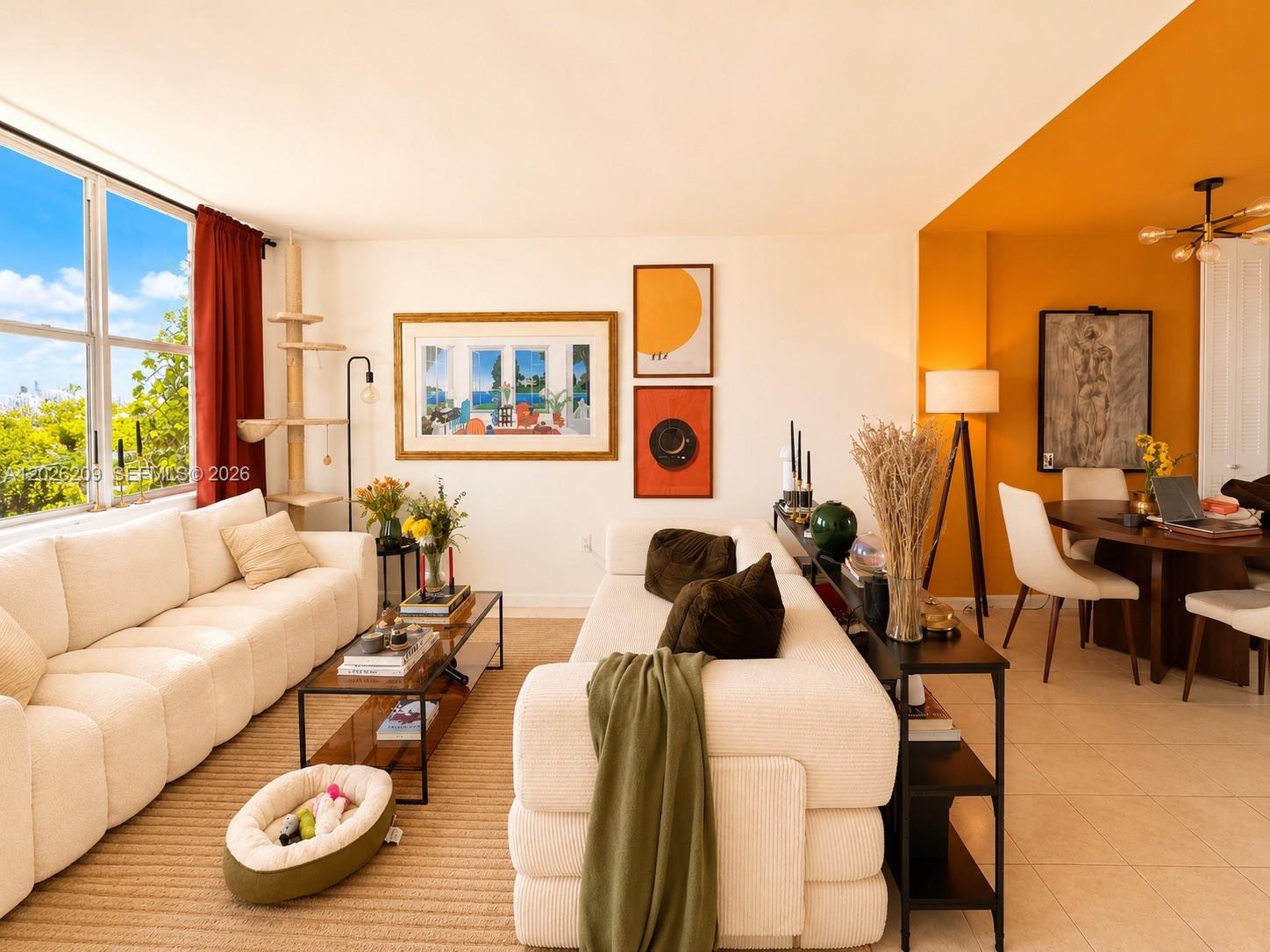 A living and dining area features white sofas, an orange accent wall, and large windows — 910 Jefferson Ave # 5C, Miami Beach FL 33139, MIAMI BEACH, FL