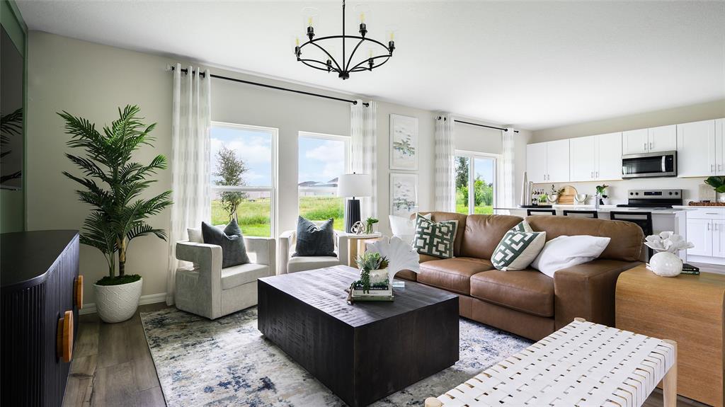 A living room features a brown leather sofa, a dark coffee table, and an open kitchen — 1747 VANILLA STREET, HAINES CITY, FL