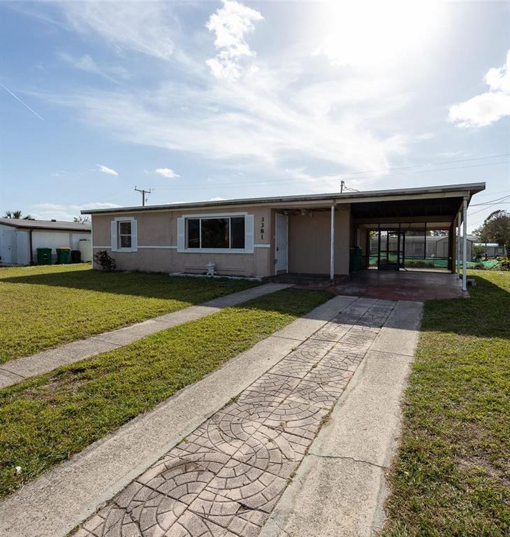 A single-story house with a tan exterior, a concrete driveway, and an attached carport — 3381 WESTLUND TERRACE, PORT CHARLOTTE, FL