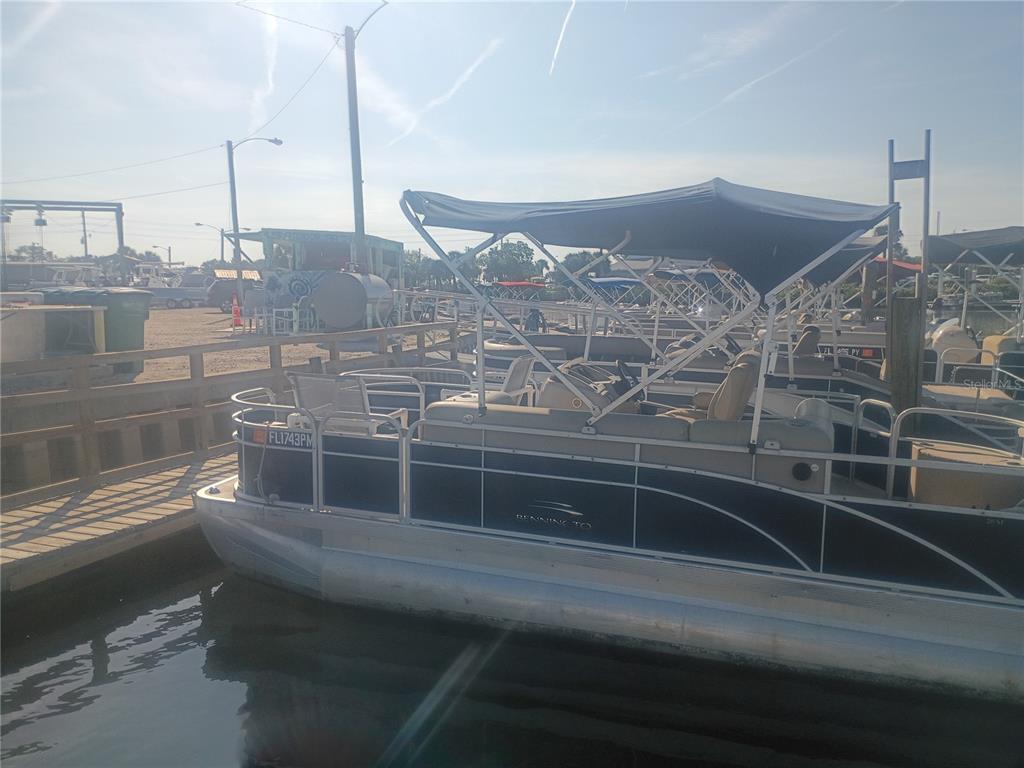 A pontoon boat is docked at a wooden pier on a sunny day — 147 MIDDLE WAY, NEW SMYRNA BEACH, FL