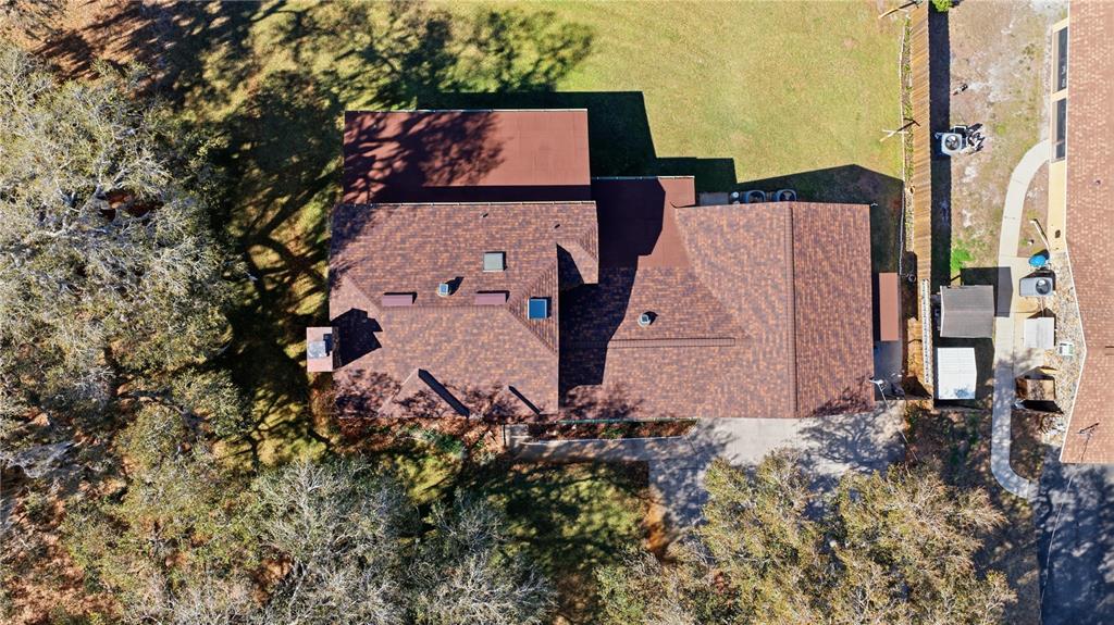 An aerial view shows a house with a brown shingled roof and several skylights — 49 N ARCHWOOD DRIVE, INVERNESS, FL