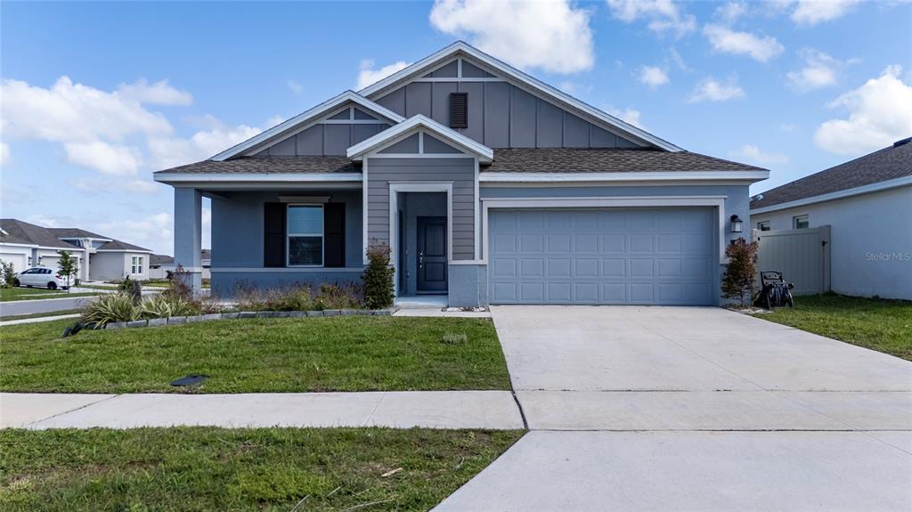 A single-story house with a blue exterior, a two-car garage, and a concrete driveway — 401 SANDBAR LN, HAINES CITY, FL