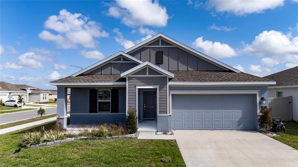 A single-story house with a gray exterior, a two-car garage, and a front porch — 401 SANDBAR LN, HAINES CITY, FL