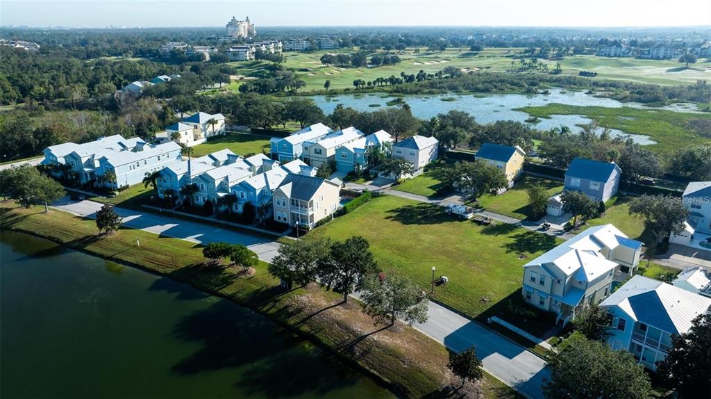 An aerial view shows a residential neighborhood with houses situated along a lake and golf course — 1523 FAIRVIEW CIRCLE, KISSIMMEE, FL