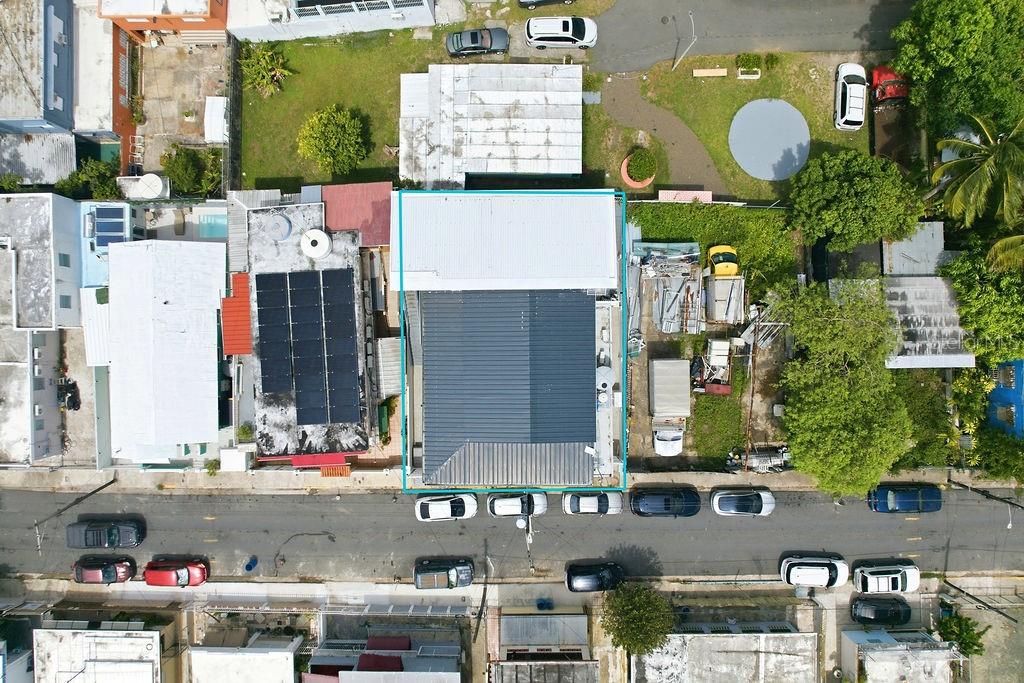 An aerial view shows a building with a dark metal roof and solar panels — 119 SANTA CECILIA, SAN JUAN, PR