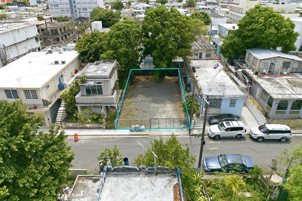 An aerial view shows a vacant, fenced rectangular lot situated between two residential buildings — 119 SANTA CECILIA, SAN JUAN, PR