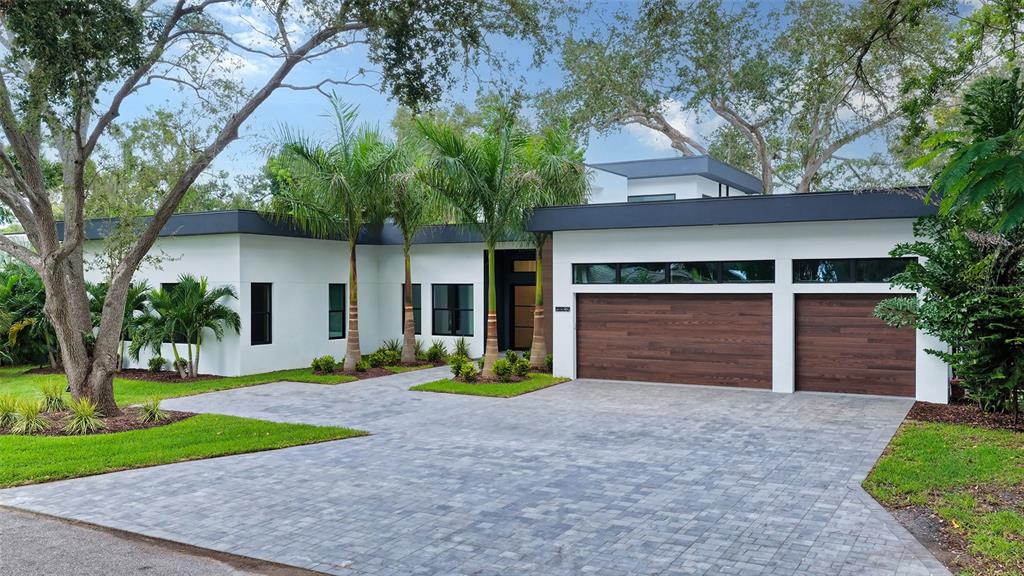A modern one-story house with a flat roof, white stucco walls, and a two-car garage — 1429 N LAKE SHORE DRIVE, SARASOTA, FL