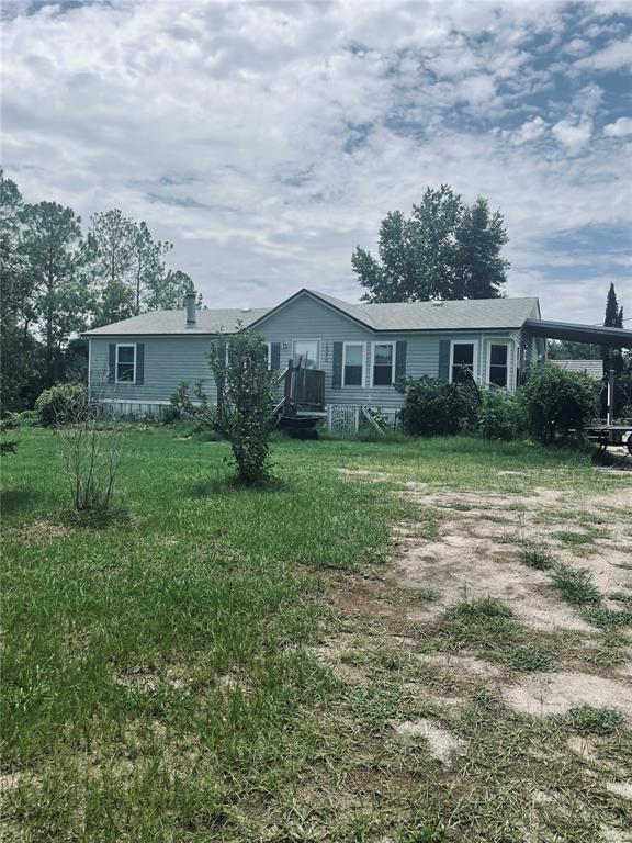 A single-story light blue manufactured home sits on a grassy lot with trees — 16570 SW 58TH LANE, OCALA, FL