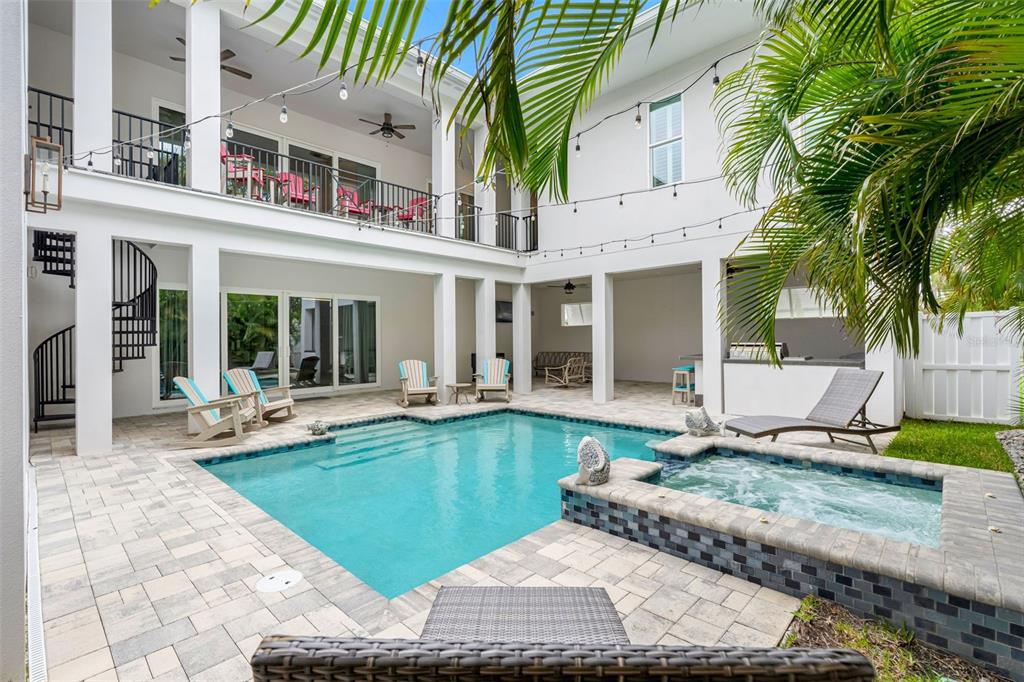 A two-story house exterior features a swimming pool, hot tub, and a second-floor balcony — 124 FOREST HILLS DRIVE, REDINGTON SHORES, FL