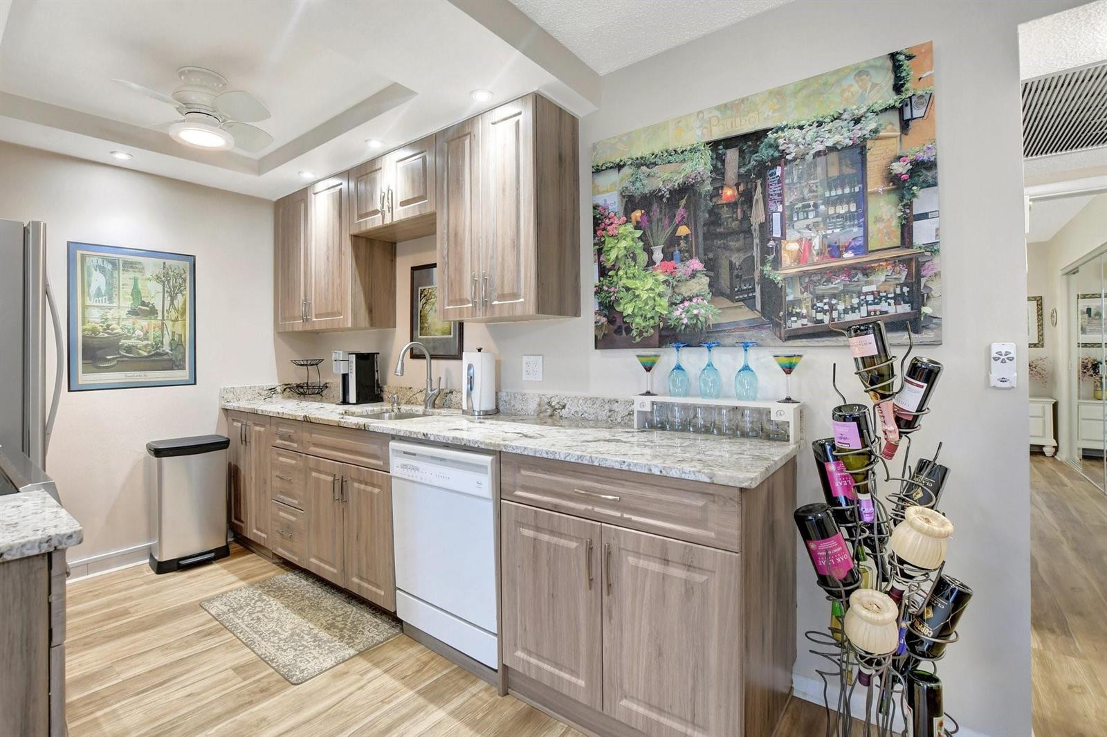 A dining room features a glass table, brown chairs, a grandfather clock, and wood flooring — 2157 Cambridge G # 2157, Deerfield Beach FL 33442, DEERFIELD BEACH, FL