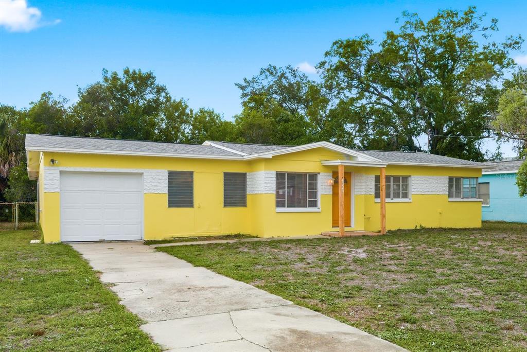 A yellow single-story house with a white garage door and a concrete driveway — 4325 S COOLIDGE AVENUE, TAMPA, FL