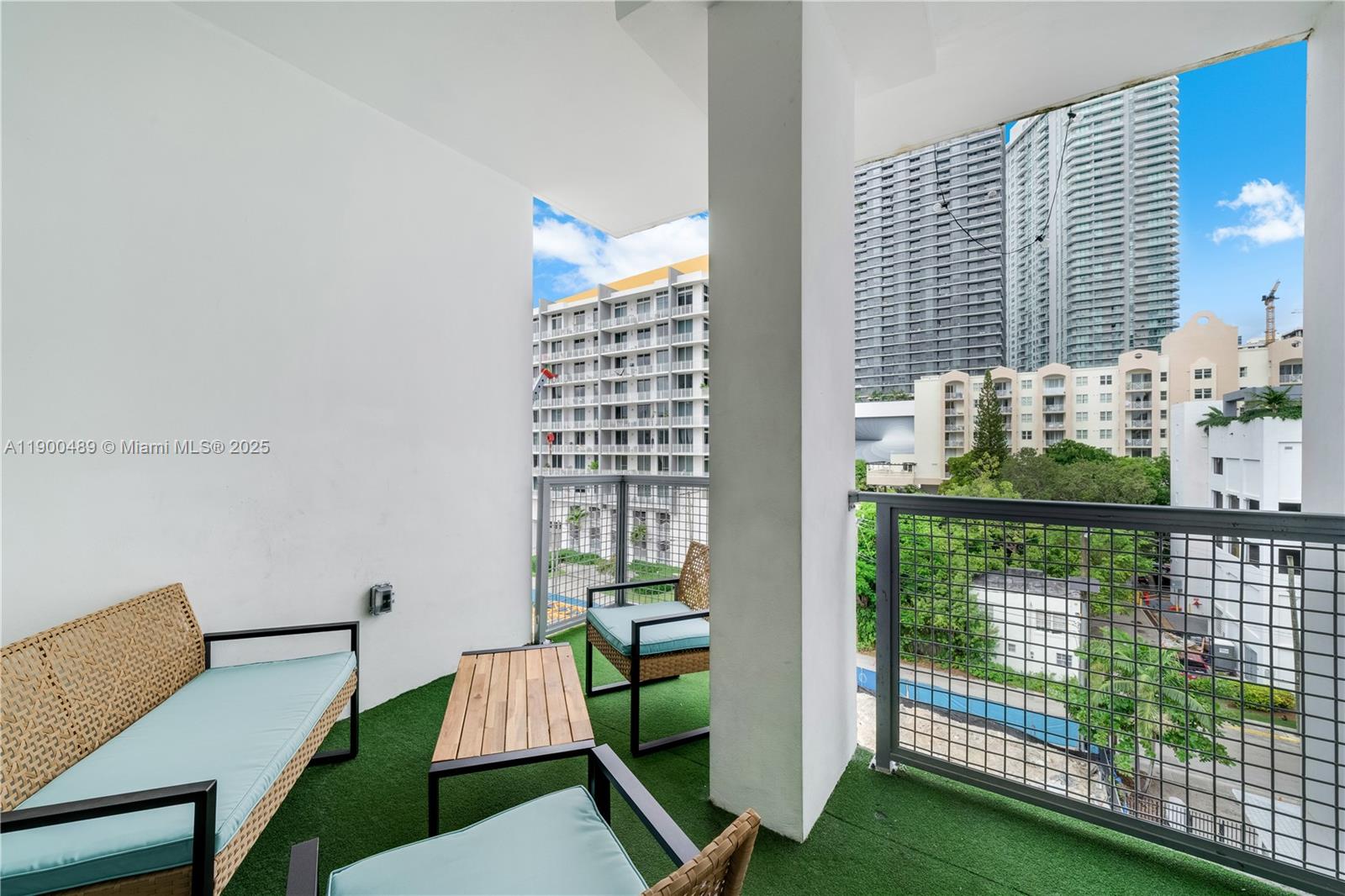 An outdoor balcony features artificial turf, patio furniture, and views of surrounding high-rise buildings — 481 NE 29th St # 601, Miami FL 33137, MIAMI, FL