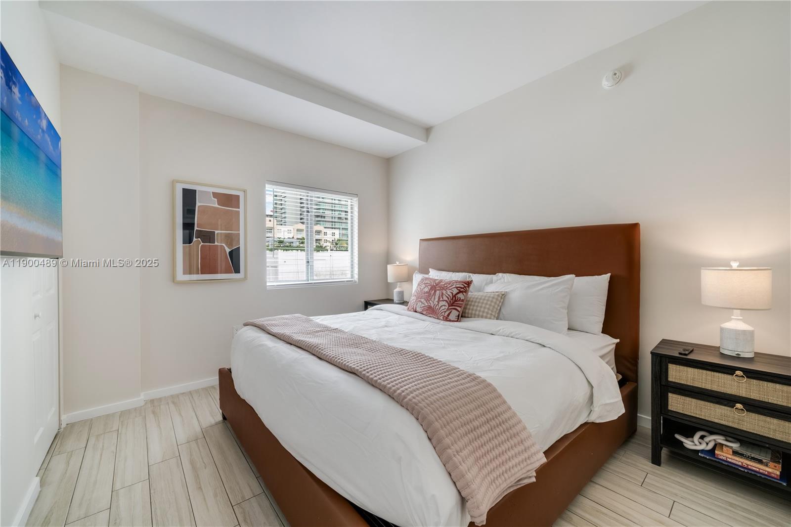 A bedroom features a brown upholstered bed, two nightstands, and a window with city views — 481 NE 29th St # 601, Miami FL 33137, MIAMI, FL