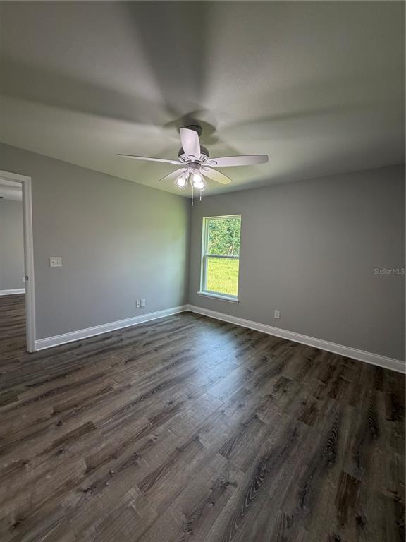 A bedroom with gray walls, a ceiling fan, and wood-look flooring — 1981 LEMON DRIVE, LAKE WALES, FL