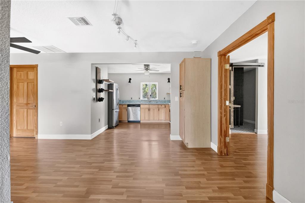 A view from a living area looking into a kitchen with light wood cabinets — 1420 E 8TH AVENUE, MOUNT DORA, FL