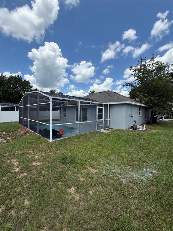 A kitchen features sage green cabinets, stainless steel appliances, and light wood-look flooring — 318 WALPOLE LOOP, DAVENPORT, FL