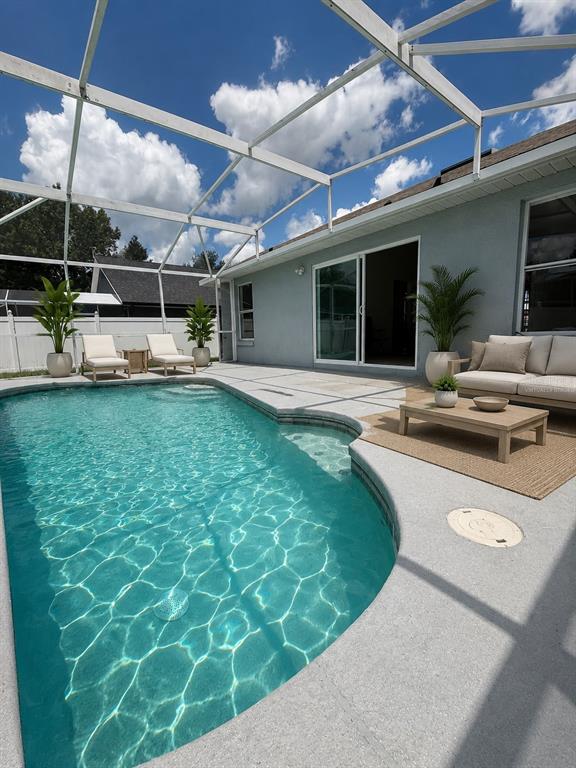 A kitchen features sage green cabinets, stainless steel appliances, white countertops, and light wood flooring — 318 WALPOLE LOOP, DAVENPORT, FL