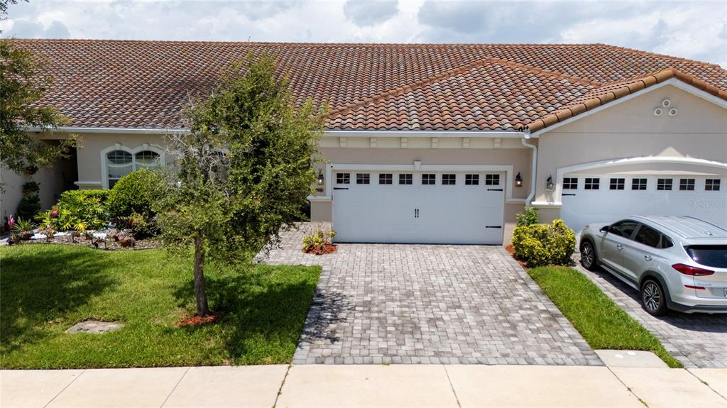A single-story house with a tiled roof, a two-car garage, and a paved driveway — 2806 PLYMOUTH PLACE, KISSIMMEE, FL