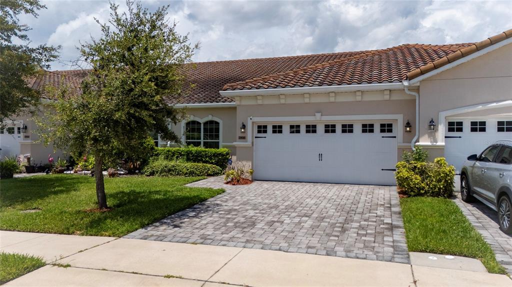 A single-story house with a tiled roof, a two-car garage, and a paved driveway — 2806 PLYMOUTH PLACE, KISSIMMEE, FL