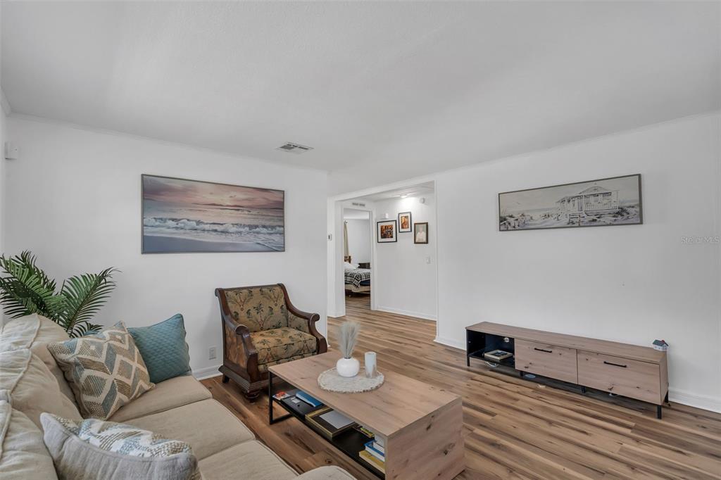 A living room features light wood flooring, white walls, a sofa, armchair, and coffee table — 373 ERON WAY UNIT 47, WINTER GARDEN, FL