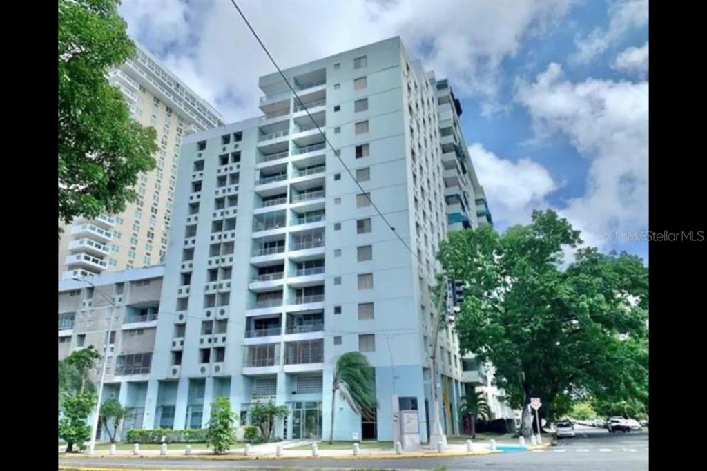 A tall, light blue multi-story residential building stands under a partly cloudy sky — 201 AVE ARTERIAL HOSTO, SAN JUAN, PR