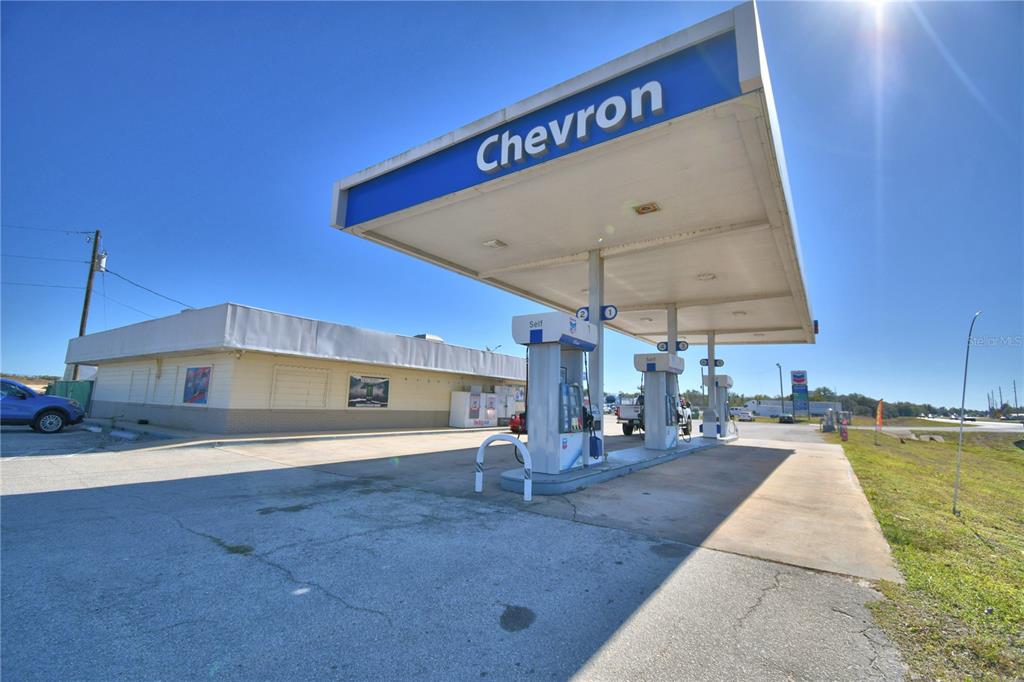 A Chevron gas station with a white building and a blue canopy over fuel pumps — 16311 HWY 27, LAKE WALES, FL