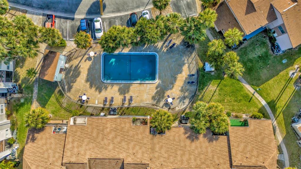 An aerial view shows a rectangular swimming pool surrounded by a patio and palm trees — 6320 NEWTOWN CIRCLE UNIT 20B1, TAMPA, FL