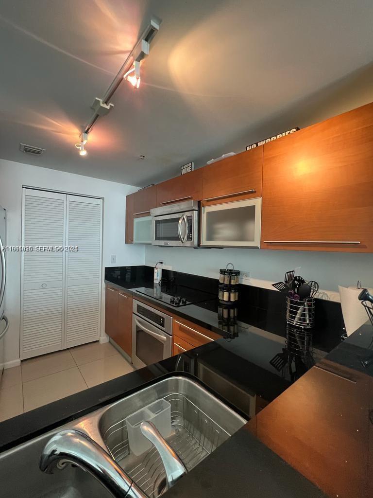 A hallway with patterned carpet leads to a wooden door labeled 3806 — 253 NE 2nd St # 3806, Miami FL 33132, MIAMI, FL
