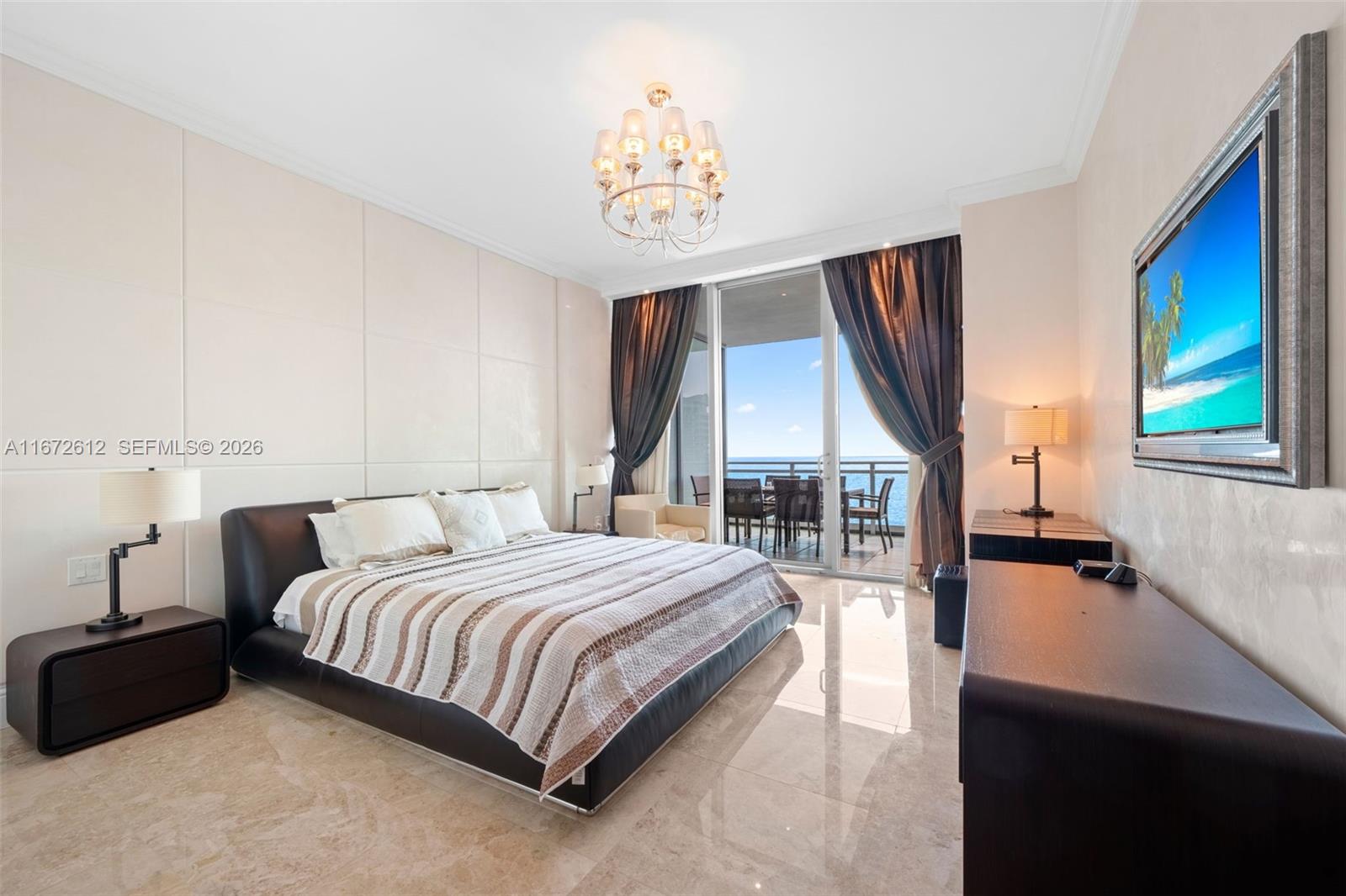 A modern bedroom features a large bed, marble floors, and a balcony overlooking the ocean — 10295 Collins Ave # 1605, Bal Harbour FL 33154, BAL HARBOUR, FL
