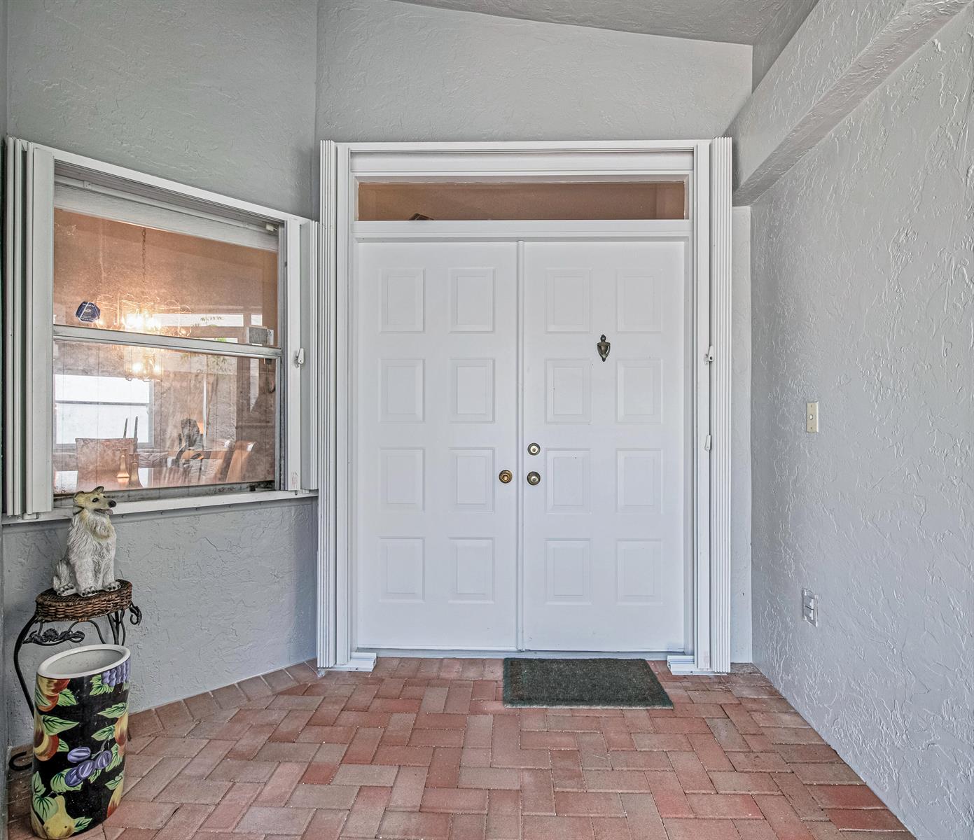 A white double front door with a transom window sits on a brick-paved entryway porch — 9822 Harbour Lake Circle, Boynton Beach FL 33437, BOYNTON BEACH, FL