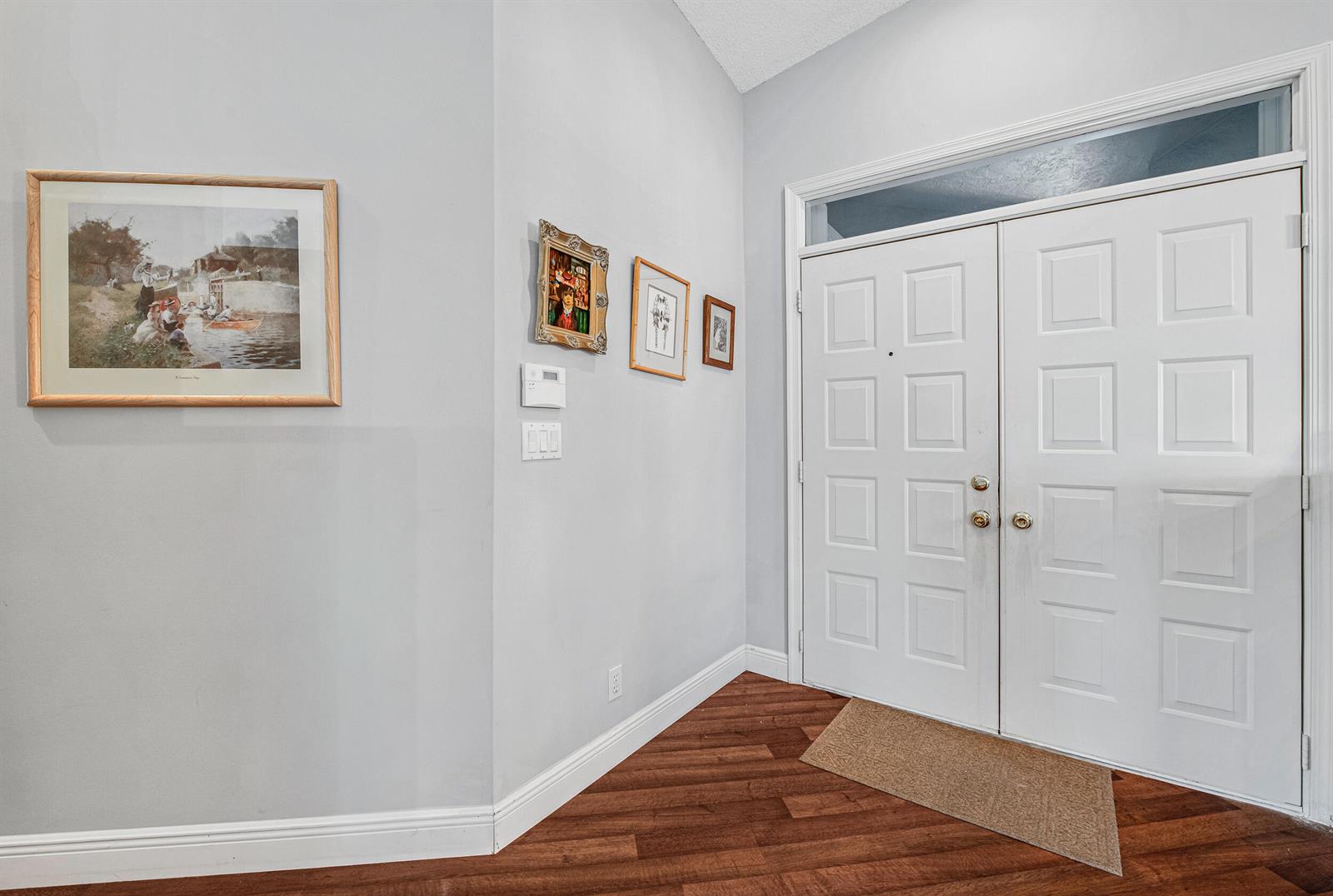 An entryway features light gray walls, wood-look flooring, a double front door, and framed art — 9822 Harbour Lake Circle, Boynton Beach FL 33437, BOYNTON BEACH, FL